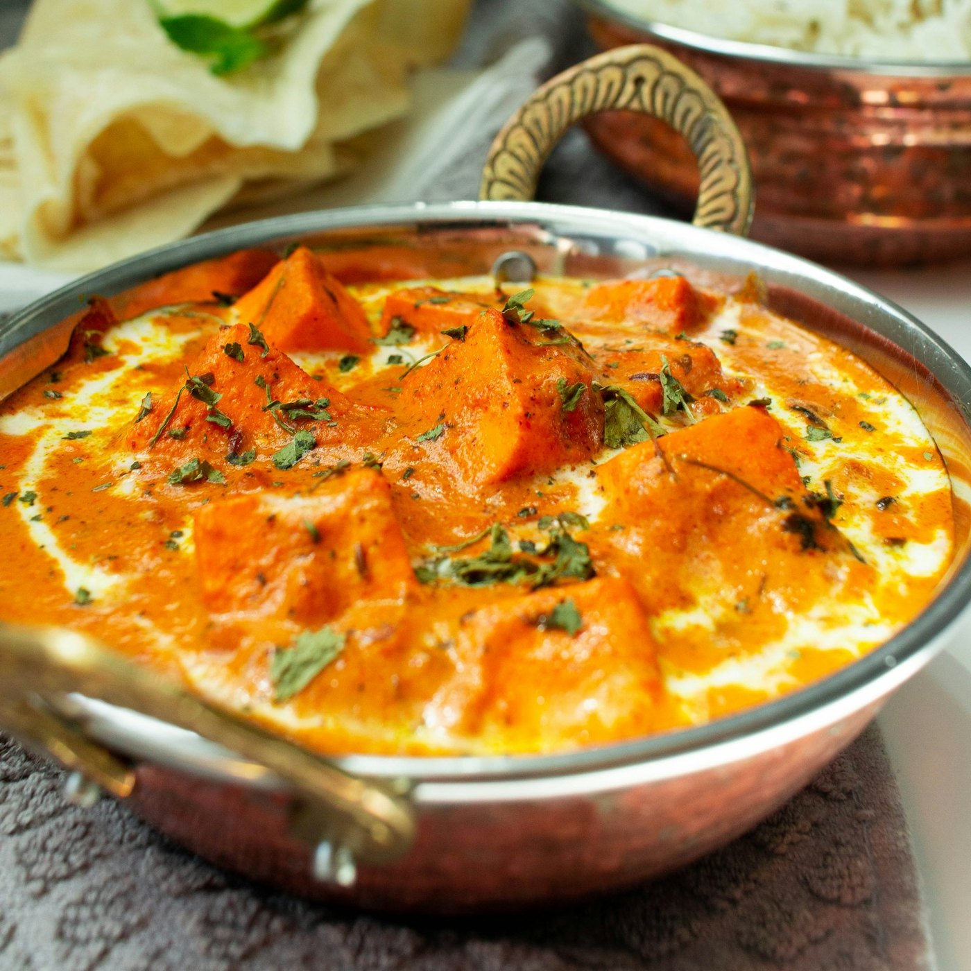 Creamy shahi paneer in a copper karahi, finished with cream and herbs.