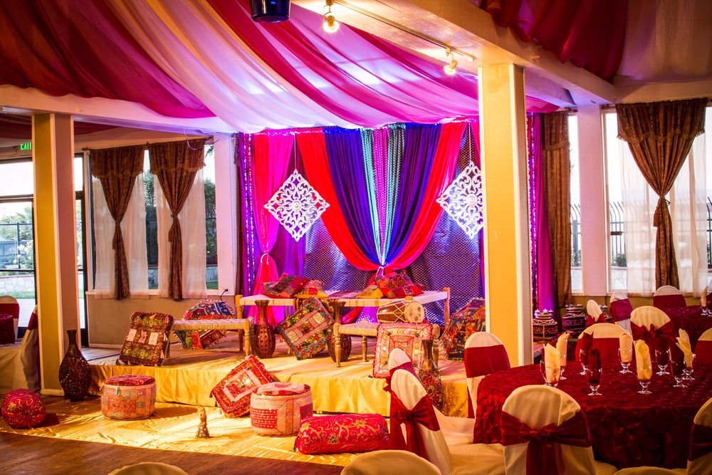 Decorated banquet hall at Raja Sweets in Union City with gold stage and set tables.