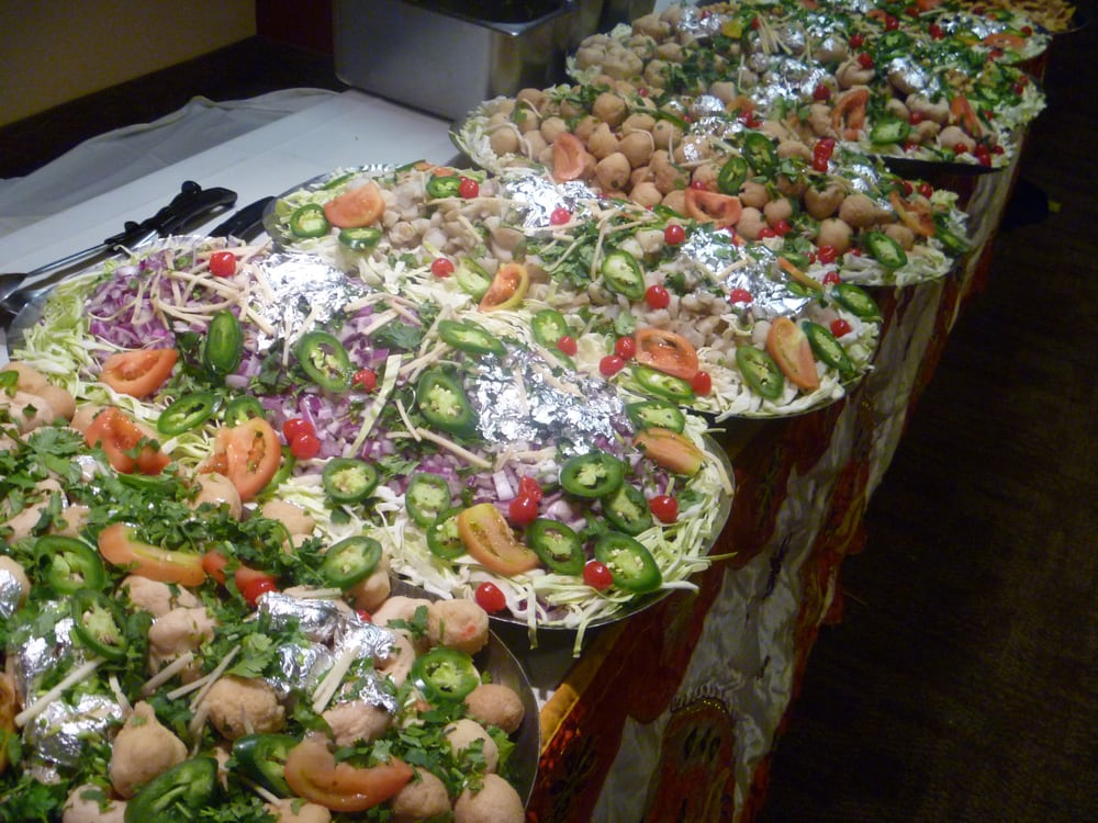 Table layout of catered food items at an indoor party.