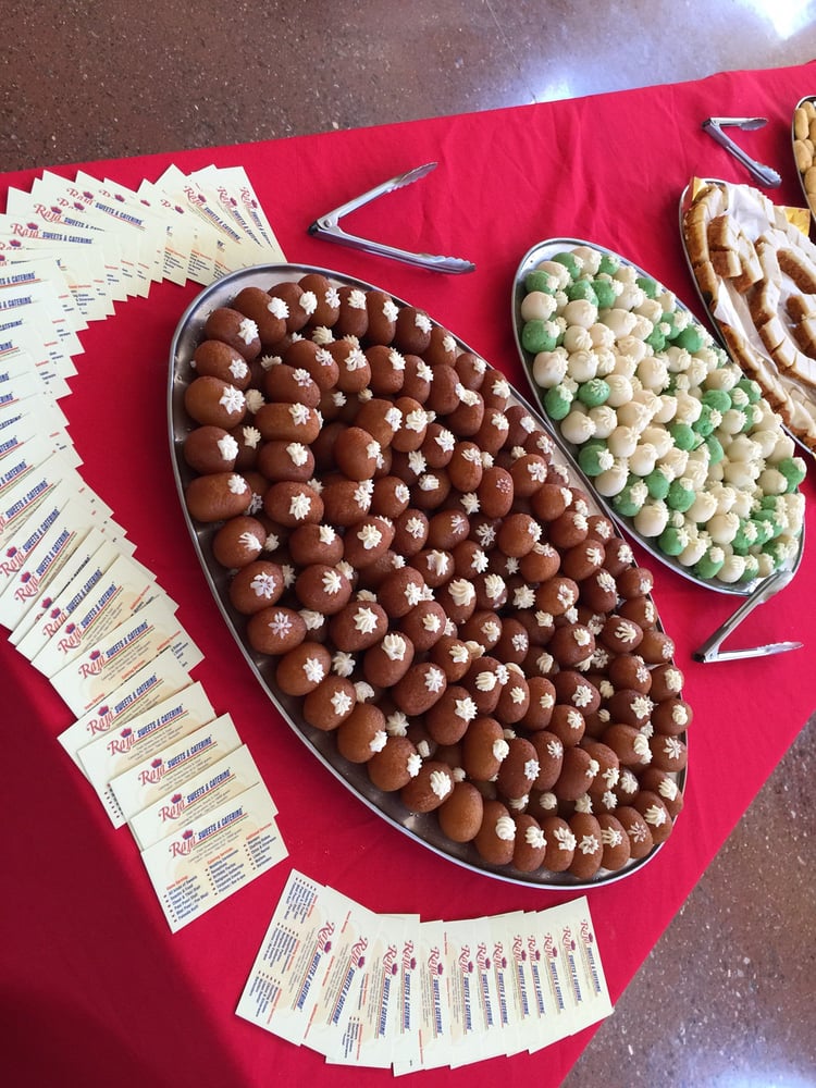 Large platter filled with dark brown sweets and green treats.