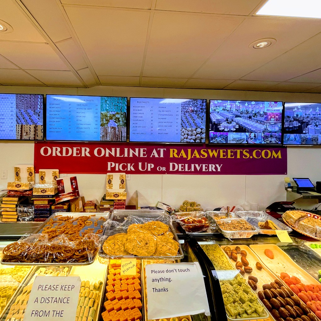 Raja Sweets Union City counter with mithai case and digital menus.